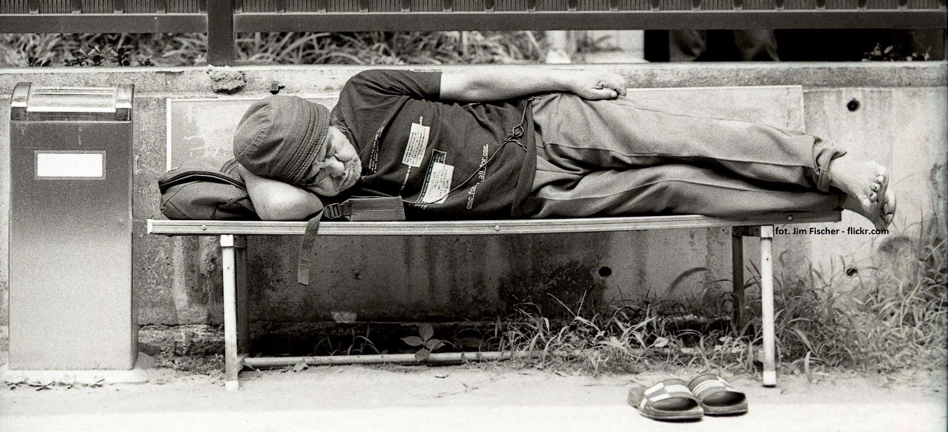 bezdomny śpiący na ławce